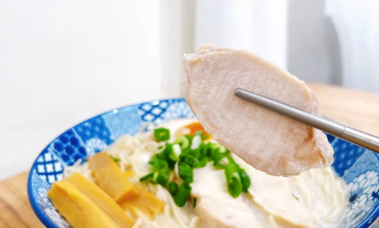 小白拉麵雞豚白湯拉麵特寫，碗內鋪滿大塊厚實的舒肥雞肉片，展現清爽低負擔的特色。