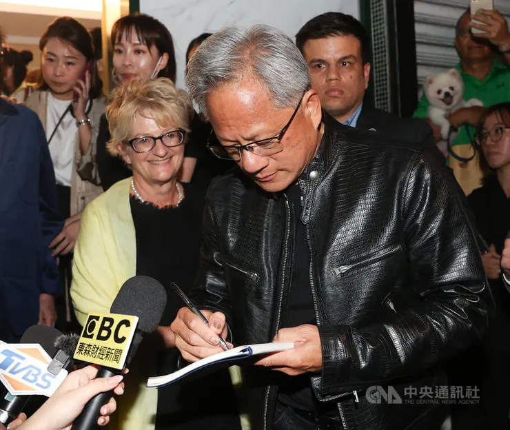 黃仁勳替觀眾簽名，妻子也到場。