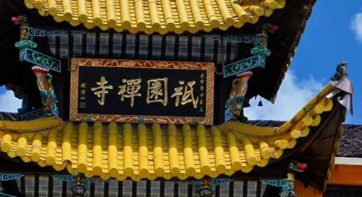 祇園寺的屋頂上，金色的瓦片和雕刻精美的屋脊與藍天相映成趣，匾額上寫著「禪禪國祀」字樣。