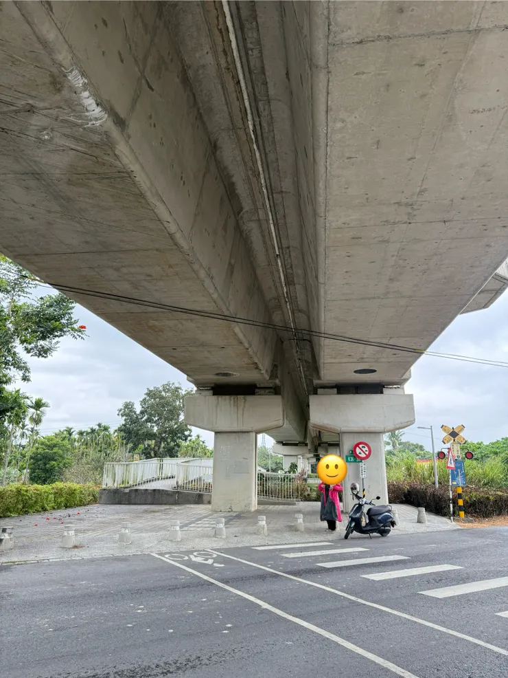 對面的機車騎士也在躲雨