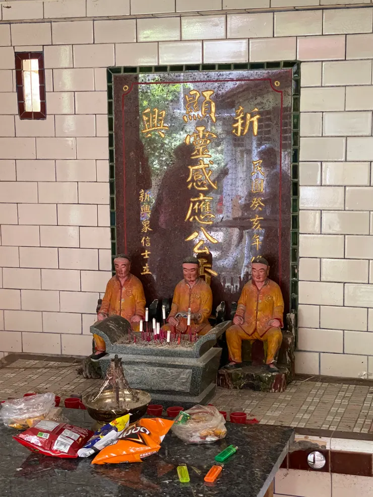 石碑刻著：新興顯靈感應公。前方擺了三尊人偶，至今意義不明。改建日期為民國癸亥年為1983年