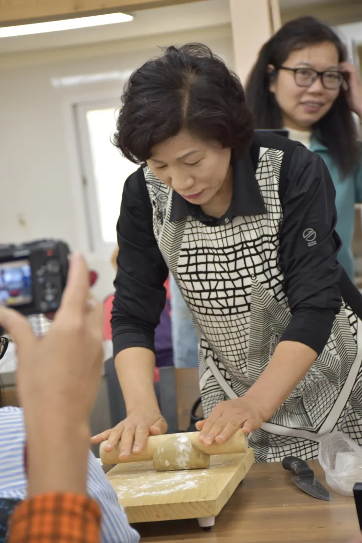 麵糰成形後，用擀麵棍調整形狀。