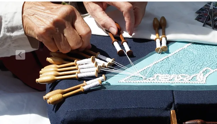 河岸邊有傳統技藝者在做著17世紀的荷蘭手工藝,這位阿嬤在織蕾絲