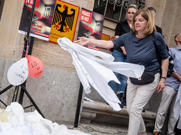 抗議的醫師在健康部前放下白色醫師袍,表達診所需要急救。圖片來源:alliance/dpa