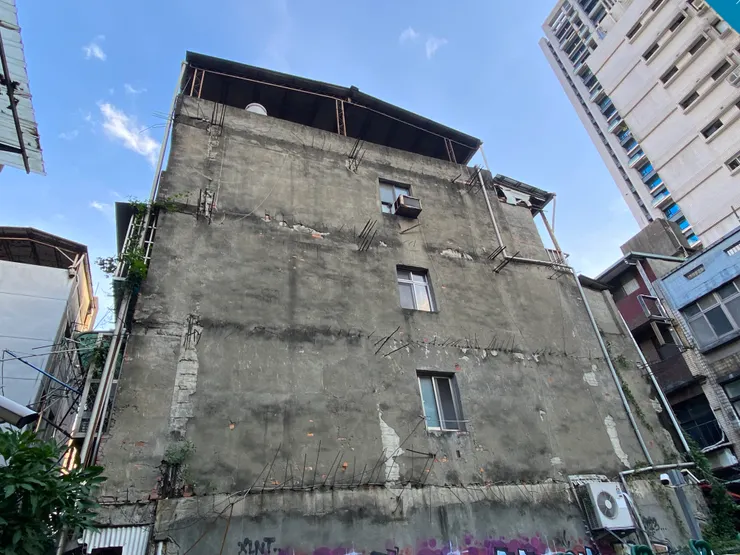 大禾邸家 - 當建築物出現「裂縫」，水氣和種子便趁機滲入，導致牆面「含水」。有時甚至會在牆上「長出植物」，更嚴重的情況可能引發水泥爆裂、鋼筋裸露、紅磚外露等現象，對牆體結構和屋內乾燥度造成不良影響。然而，此照片中牆面所見的一根根鋼筋，實際上是先前預留的搭接鋼筋，並非因損壞而暴露。但需要注意的是，若當時防水處理不夠完善，這些部位也可能成為未來漏水的潛在破口。