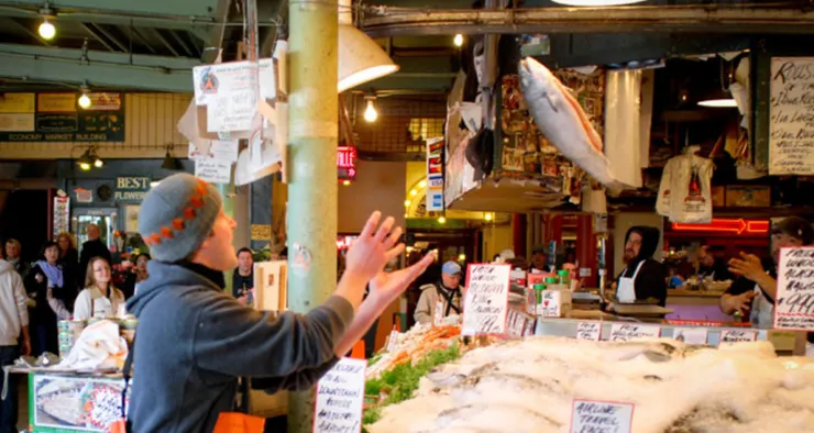 派克市場的丟魚秀，魚販正將一條肥美的魚二兒往上拋的精彩畫面。（圖截自網路）