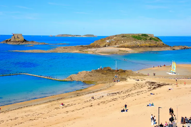 【沿沙灘遊人戲水遛狗散步閒坐 市徽裡的帆船星點環繞國家堡】