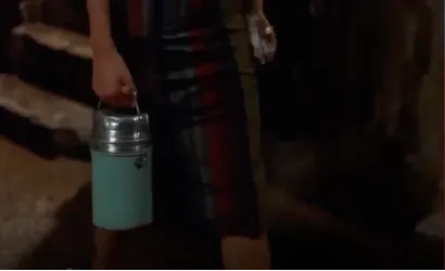 蘇麗珍前往租屋處樓下麵攤買麵，手提保溫瓶下樓梯貌。