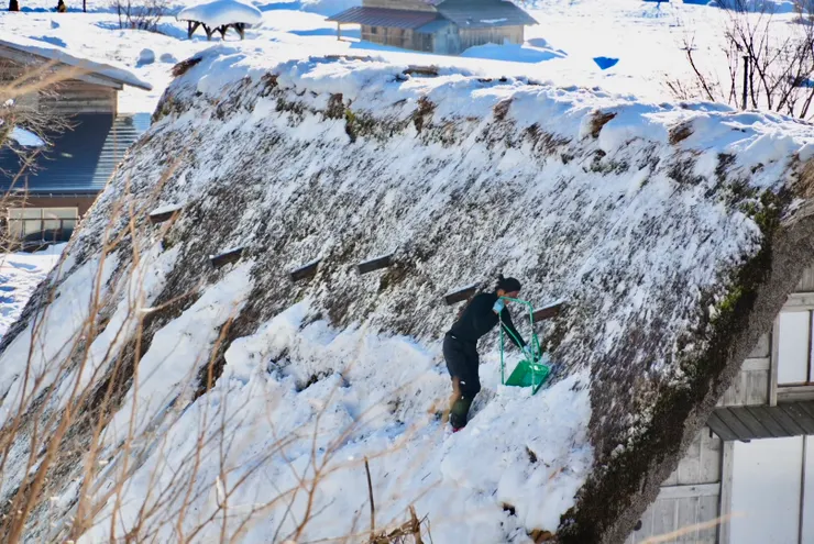 恰好遇到居民上屋頂清除積雪