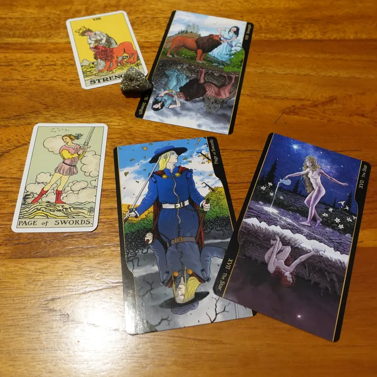 比例尺...畫面左邊兩張較小的就是Tarot Original 1909 Mini的牌卡。畫面裡比較大的那三張則是另一副牌、這尺寸是大部分標準塔羅牌的size。