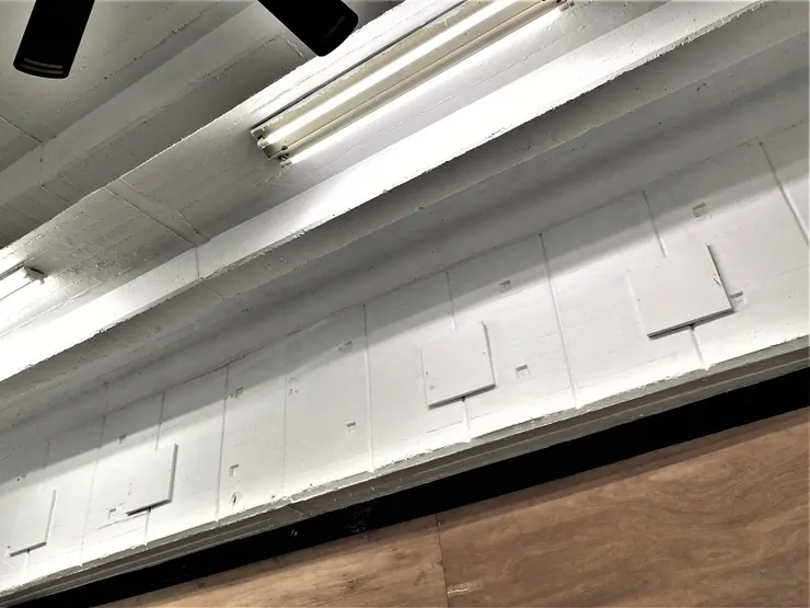 牆面上內凹小方孔為模板固定點，灌漿拆模後留下，呈現當年的施工技術。較深的垂直凹痕，則是裝飾線條