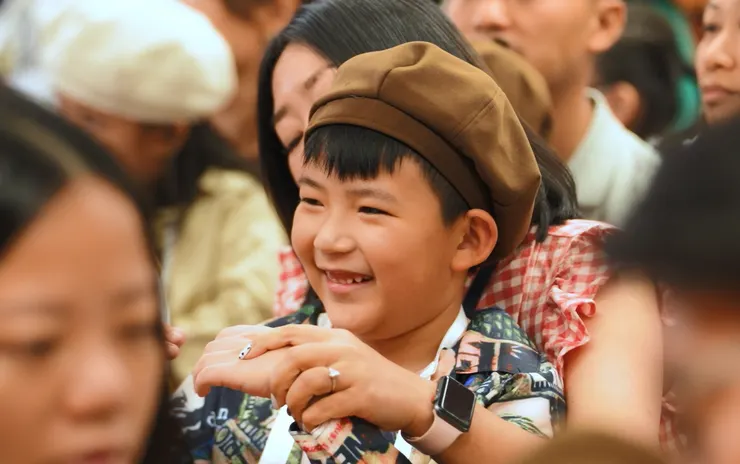 小孩在母親的懷裡展現燦爛的笑容