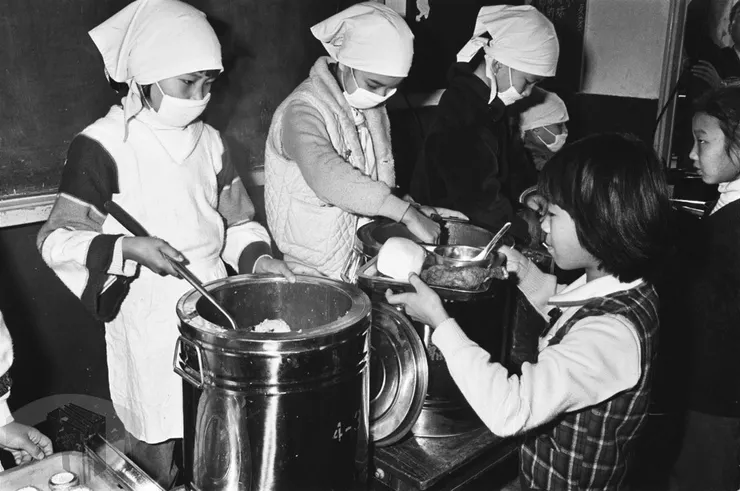 圖12 學童們排隊持拿餐盤領取午餐 案名:民生、服裝、飯店、飲食 檔號:0059/0045/1 來源機關:行政院新聞局 管有機關:國家發展委員會檔案管理局