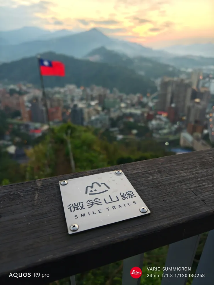 小獅山夕色與微笑山線標誌。得益於1/0.98吋感光元件,柔和自然的散景是標準鏡的強項(SHARP AQUOS R9 pro,23mm)