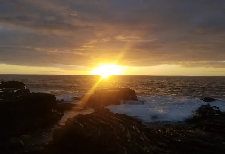 大島的夕陽。前方的近景是火山熔岩凝結後的黑色lava