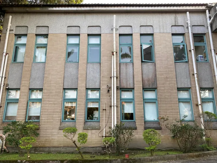 女兒牆接近屋頂處以斬假石處理做收，使平面維持三段式原則