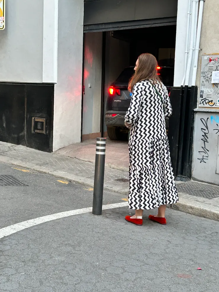 全身黑色條紋洋裝,僅以一雙紅鞋成亮點。