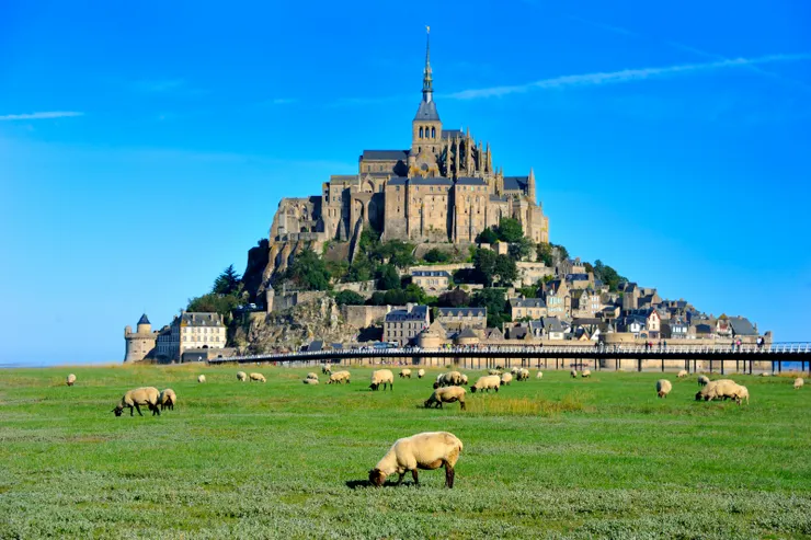 【從停車場到標的別偷懶搭接駁車 四十五分鐘走拍三公里絕不嫌多 大天使尖頂守望盼人間歲月靜好 山下羊群悠哉吃草彷彿千年無波！仔細看，修道院尖塔頂端是尊金色雕像，即聖米歇爾大天使，為1897年法國著名雕塑家Emmanuel Frémiet作品。】