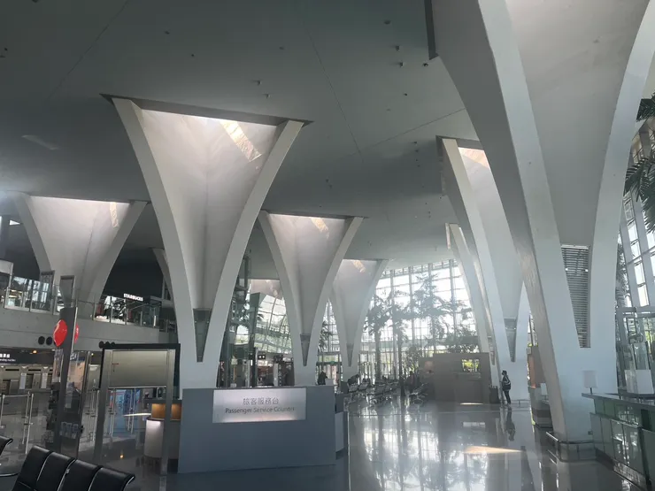 （田中）彰化高鐵站：車站大廳。車站的屋頂呈現田埂般的起伏韻律，以花朵意象的天窗，引入光線照亮室內大廳，讓乘客一走進去就能感受其張力。站內的站內18座弧形花柱則宛如樹林，讓微風與自然光在站內溫柔流瀉。