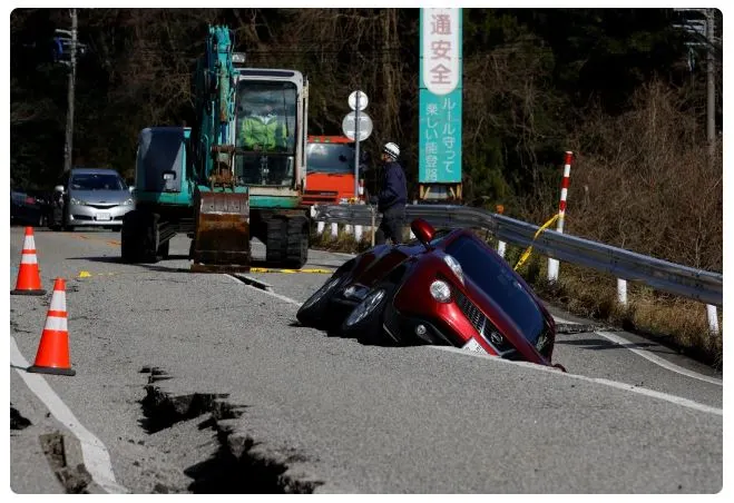 日本石川地震後一輛汽車卡在道路裂縫中的景象。(路透社)
