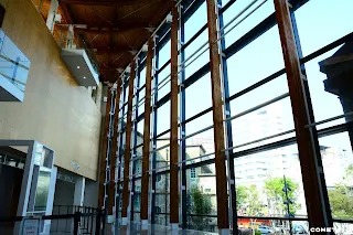 光線透過玻璃帷幕照在木色的裝潢上，呈現溫潤感