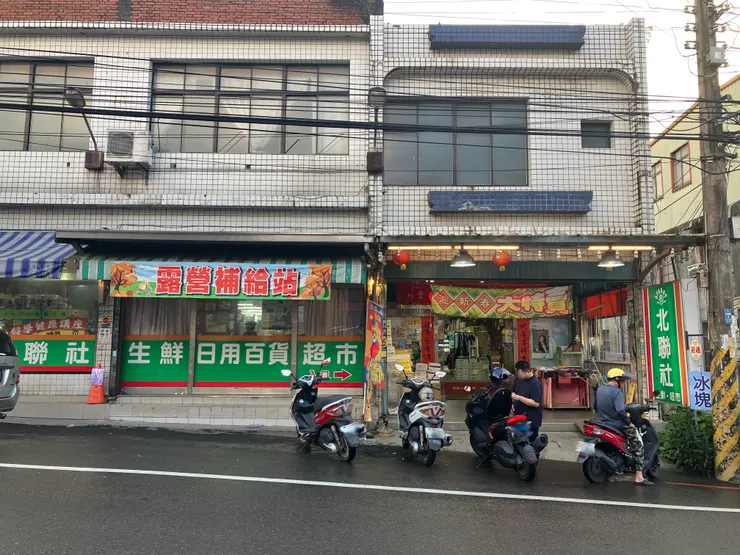 前往五峰鄉路上的日用百貨超市，掛著「露營補給站」的帆布