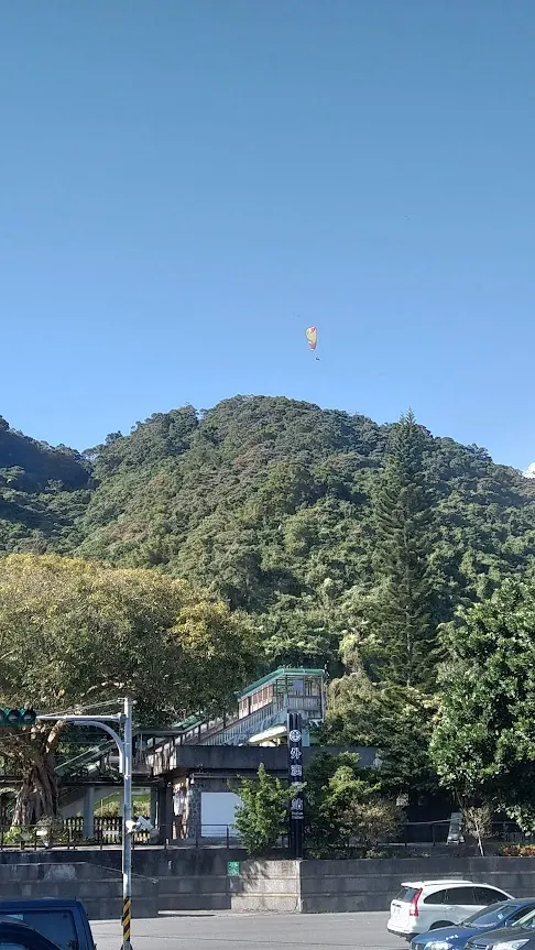 步道的入口，可看到有人在玩飛行傘