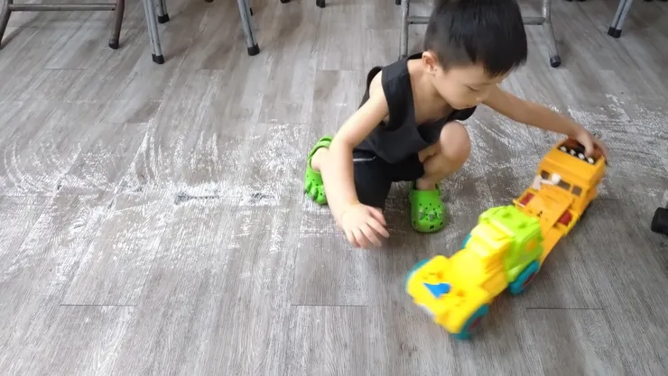 他哼著垃圾車音樂、玩著手上的小汽車