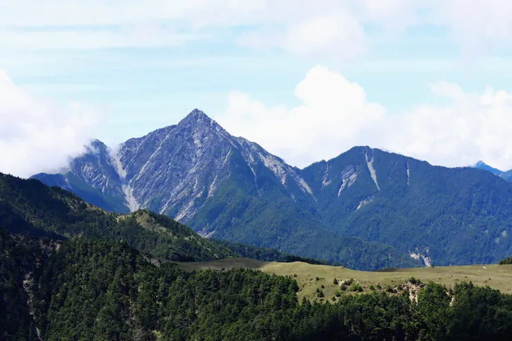▲草原對面草坡白點為有名的南湖飛機殘骸。  (1989/6/10龍翔航空公司一架直升機遇到氣流不穩失控，緊急迫降山谷內，所幸機上六名人員均無傷亡)