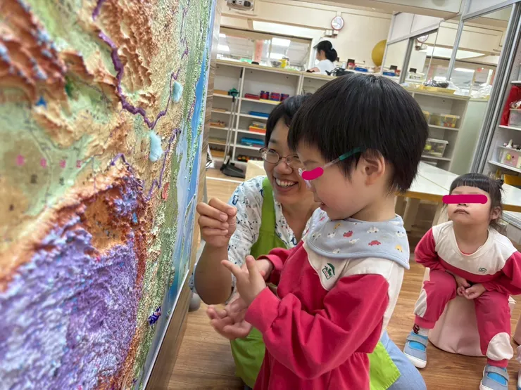 孩子在立體地圖裡找隱藏的訊息