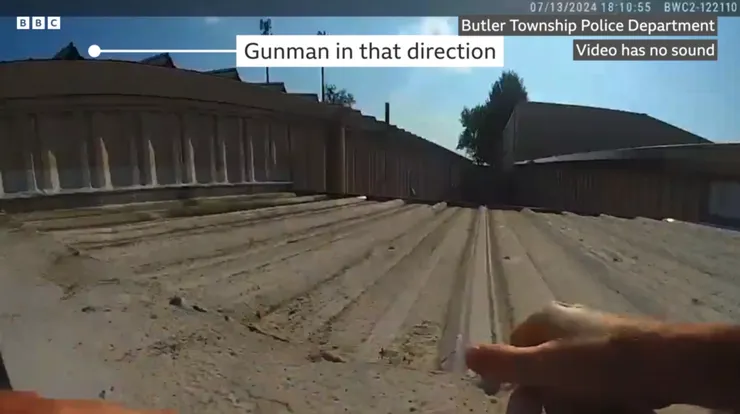 槍手位於畫面左側處，此時已持槍瞄準攀爬至屋頂的員警(畫面來源：BBC)