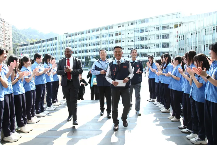 竹林中學同學於校園入口整齊列隊，以熱烈掌聲迎接貴賓到訪