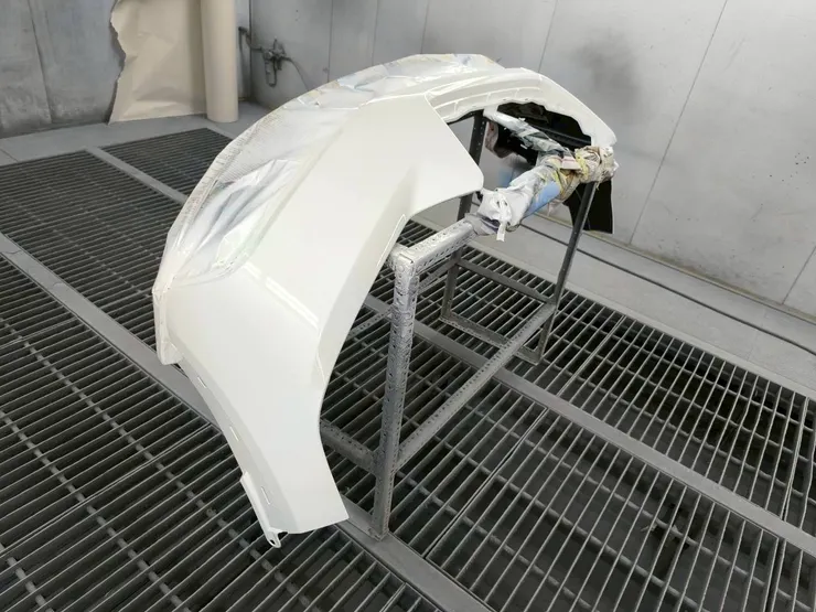 葉子板在烤漆房內噴上白色漆