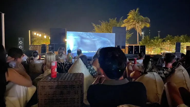 夜間露天電影院，大家躺在懶骨頭上吃晚餐看電影