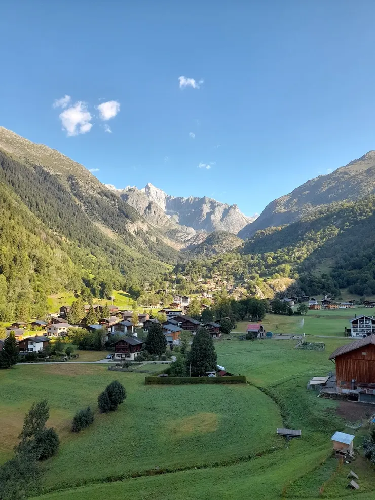 從住處拍出去的景色，隨著太陽緩緩升起，這個山谷會慢慢被陽光覆蓋。圖中也可見多棟瑞士木屋。
