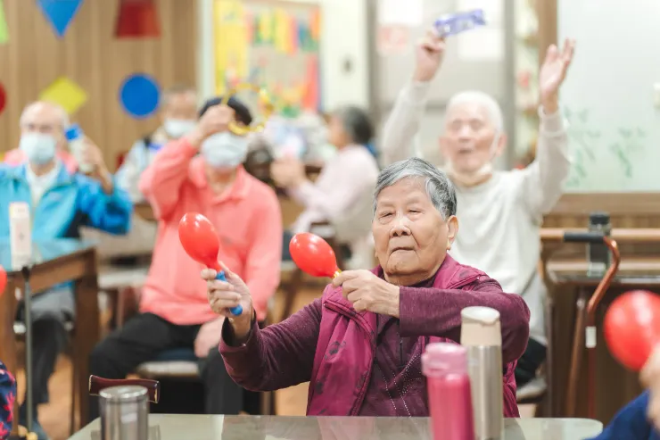 秀妹阿嬤跟著音樂節拍搖著沙鈴。