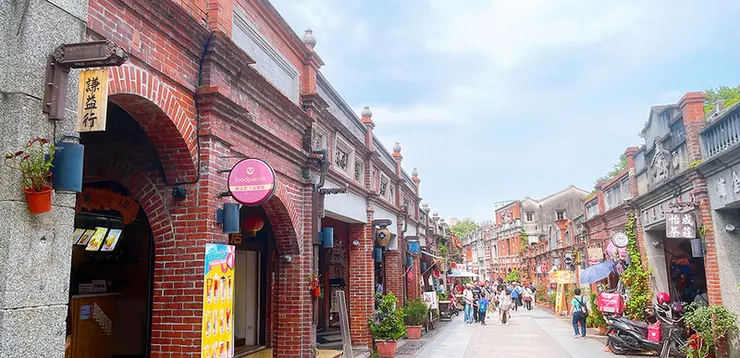 三峽老街整齊的紅磚拱廊建築，遠處可見謙益行、怡成茶莊等古色古香的商號招牌，是台北近郊最具代表性的歷史街區景點。