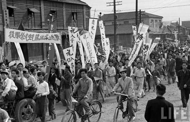 1950年台北入伍遊行，大街小巷許多人拿著還帶有些日本風格的布條旗幟，歡送要入伍的新兵。圖片來源自：台灣回憶探險團