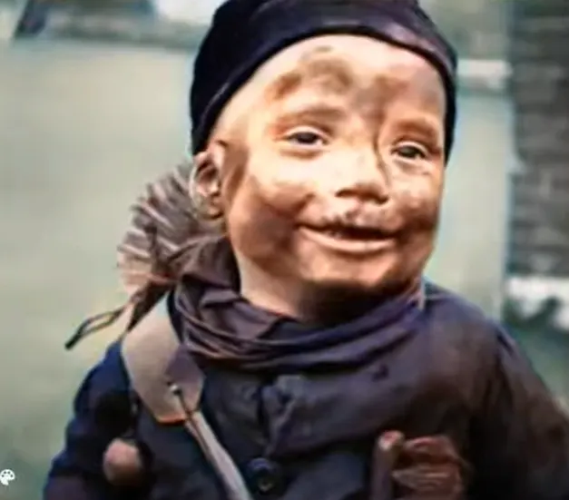 一位打掃煙囪臉上滿是煙灰的兒童。