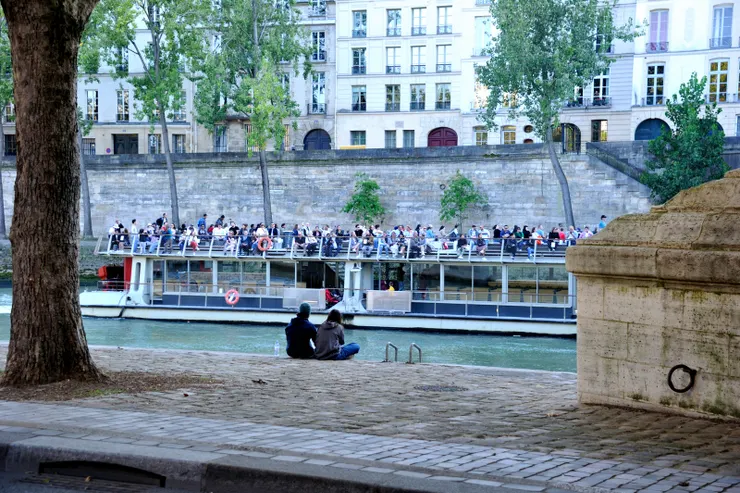 【塞納河觀光船往復岸邊遊人消閑】