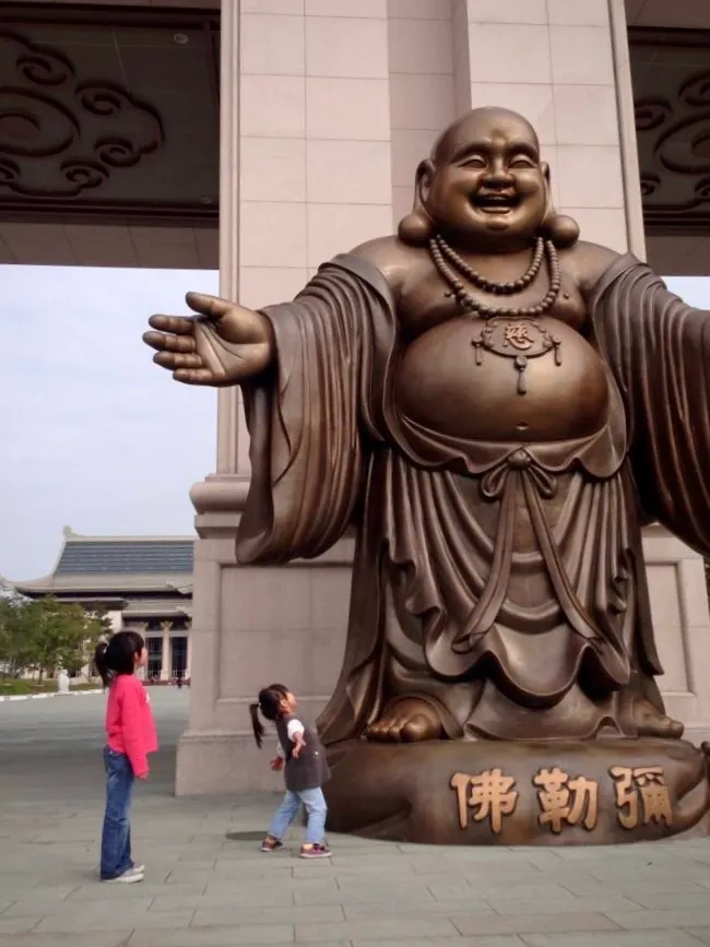 超巨彌勒佛像,左下角是正在模仿大佛姿勢的搞笑孩兒二號🤣