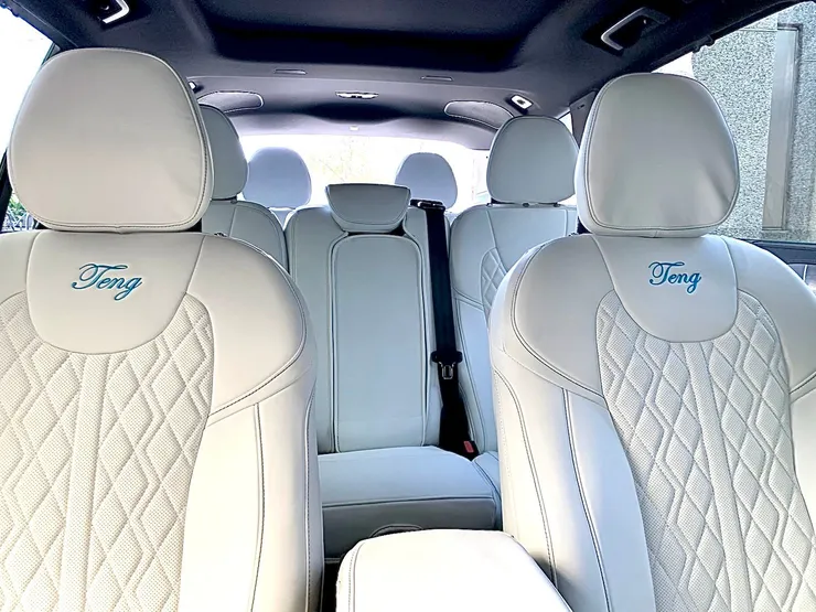 a man sitting in a car with his hand on the steering wheel