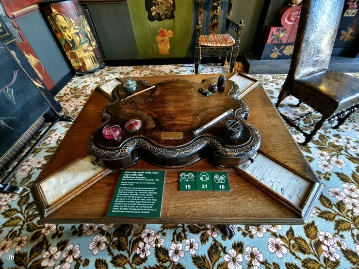 【中國風客廳裡的「墨水瓶盒」，喬治·雨果（Georges Hugo）為博物館成立而捐贈。 雨果夫人曾向拉馬丁、大仲馬、喬治·桑等人索要他們的墨水瓶和筆以作紀念。 維克多·雨果製作了一個四層抽屜的盒子來保存這些物品。 1903年，保羅·莫里斯將其固定在現在這張飾有四隻怪獸的桌子上。】