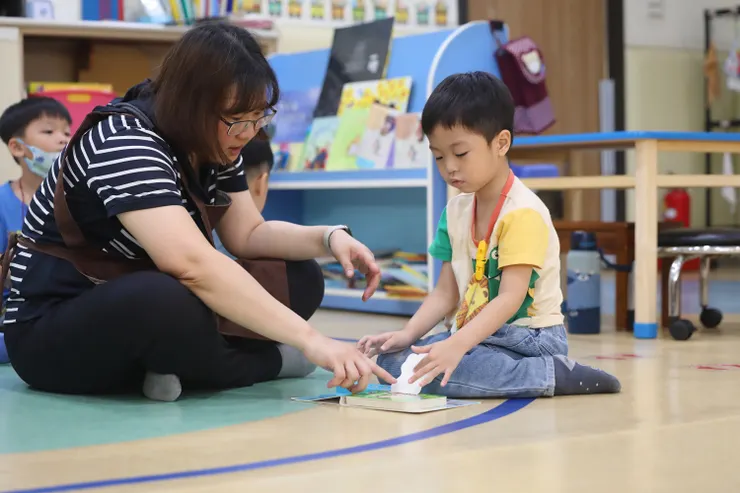 （圖說：教保員陪伴皓皓閱讀繪本，練習專注、理解，也慢慢學習與世界互動。）