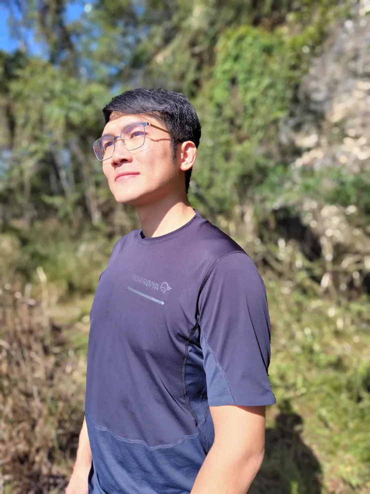 光線好的林道上,再請小曾幫我用人像模式拍一張。試了幾張會把左邊鏡框一起抹掉的失誤照後,得到這張效果最好的照片。但有一個地方似乎不管哪家的手機都算不到...那就是鏡片後面的景深,依然十分清楚,大概也是少數可以不用放大就簡單判斷淺景深照片是手機算的還是大光圈鏡頭拍的的依據之一了吧!