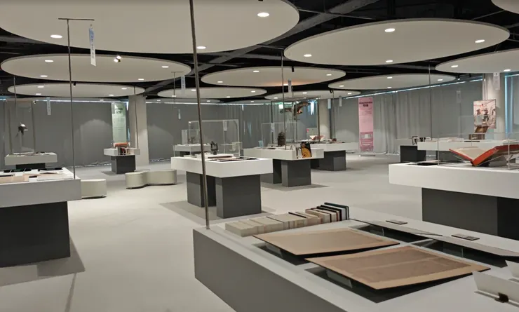 整潔的白色展臺與淺灰地面，搭配圓形吊頂與柔和燈光，為古籍、藝術品等展品提供了沉穩的展示空間