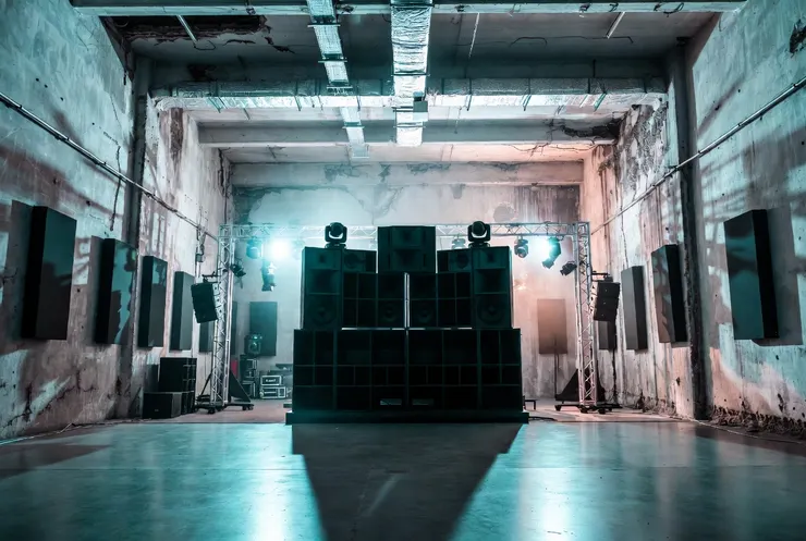 教堂裡的聖碑：一套世界頂級的定制音響系統（如 Funktion-One），完美地安裝在充滿歷史痕跡的粗糙混凝土牆面上。這象徵著「非法能量」被導入了「專業載體」。