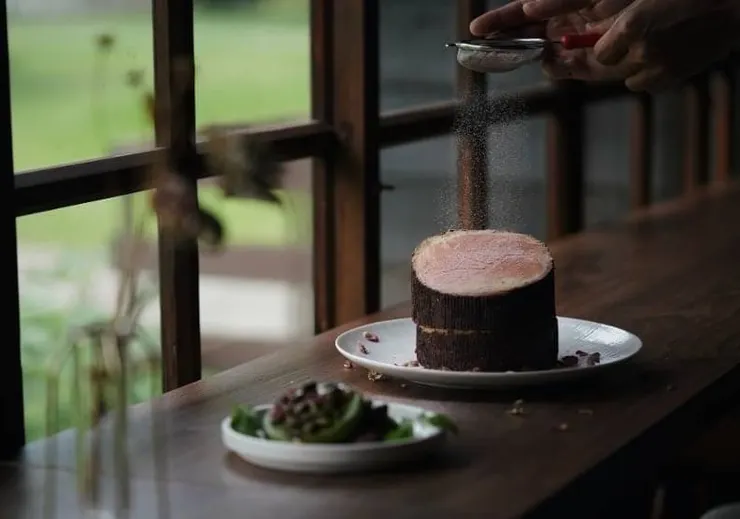 打貓咖啡「森呼吸」中層夾著焦糖核桃乳酪及地方老字號「新港源發號」的醬油，搭配上層黑藏草莓乳酪，創造出地標射日塔的幸福印象