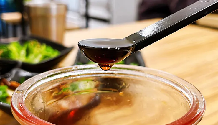 將小白拉麵特製辣油滴入蒜味豚骨拉麵中，紅艷色澤引人食慾，展現一碗多吃的豐富層次變化。