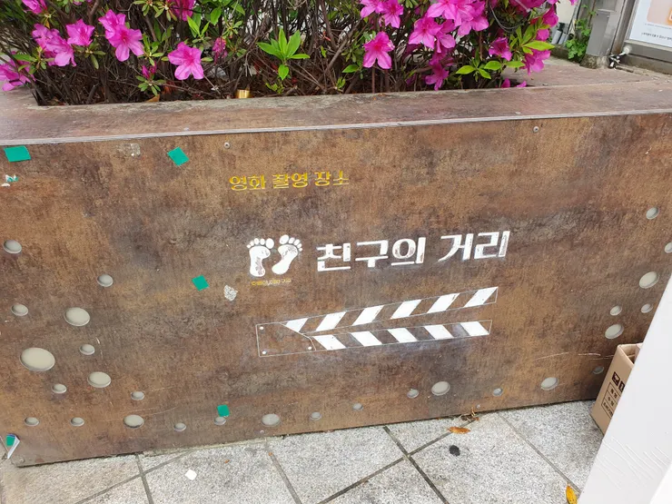 路邊的花壇上寫著「電影拍攝地：朋友的街道」